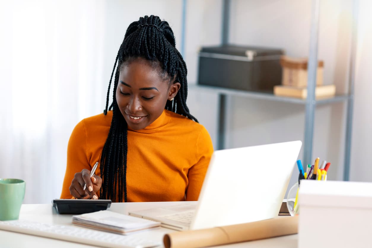 Young woman calculating her payments in front of a computer